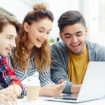 tres estudiantes mirando un ordenador portatil